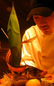 Our chef leans toward the camera as he puts the finishing touches on an elaborate sushi platter