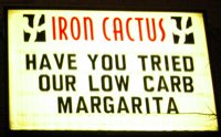 A lighted sign that reads "HAVE YOU TRIED OUR LOW CARB MARGARITA"